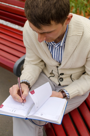 Man is writing at the notebookの写真素材
