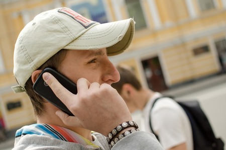Young man using his black cell phoneの写真素材