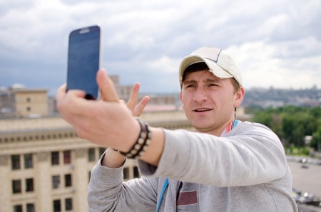 Young man making selfie with his cell phone