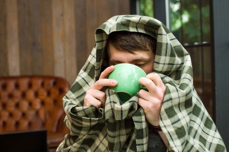 Young man drinking hot coffee from the cup