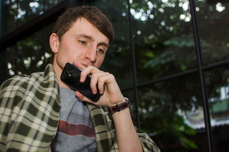 Young man using his black cell phone