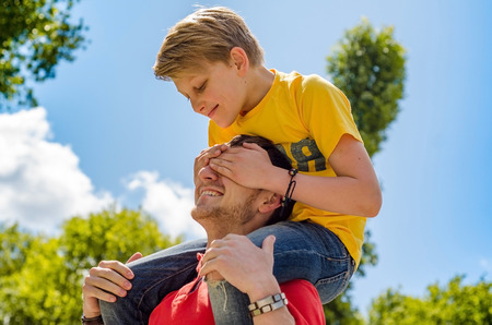 Teenages is sitting on young man's neck in the parkの写真素材
