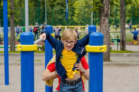 Young man is heling teenager on the breams in the park