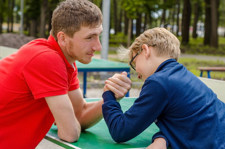 Young man is playing with teenager in the parkの写真素材