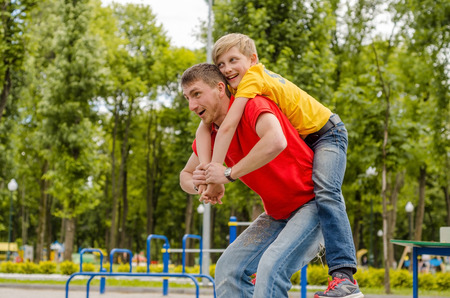 Young man is playing with the teenager in the park