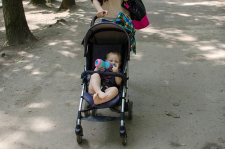 Young mother is walking with her small child in the park