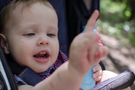 Small baby boy is drinking from the colorful bottleの写真素材