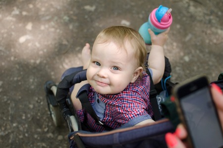 Young mother is walking with her small child in the parkの写真素材