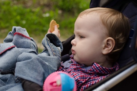 Small baby boy is drinking from the colorful bottleの写真素材