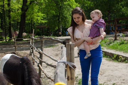 Young mother is walking with her small child in the parkの写真素材