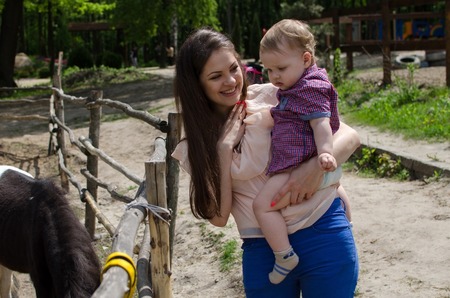 Young mother is walking with her small child in the parkの写真素材