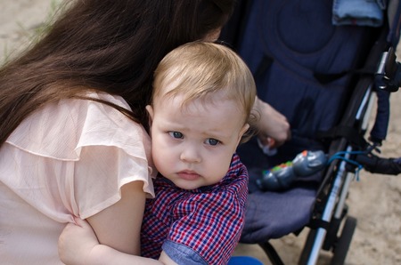 Young mother is walking with her small child in the parkの写真素材
