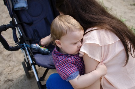 Young mother is walking with her small child in the parkの写真素材