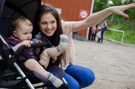 Young mother is walking with her small child in the parkの写真素材