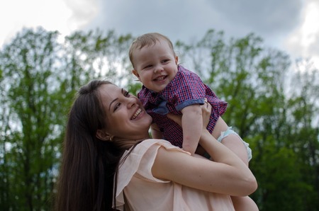 Young mother is walking with her small child in the parkの写真素材
