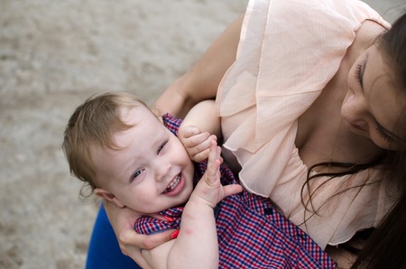 Young mother is walking with her small child in the parkの写真素材