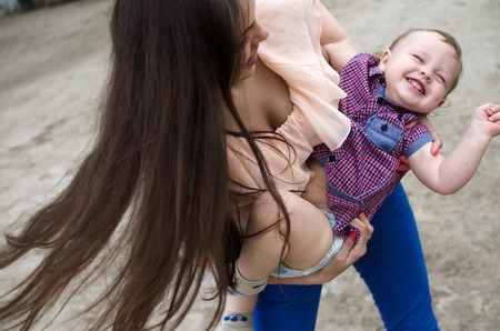 Young mother is walking with her small child in the parkの写真素材