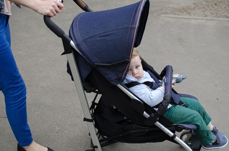 Mother with her small baby bo are walking in the parkの写真素材
