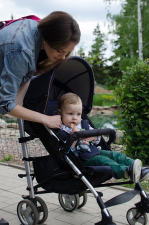 Mother with her small baby bo are walking in the park
