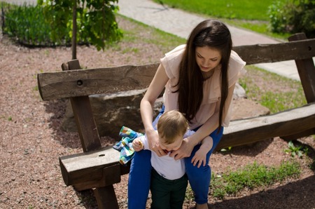 Young mother changes clothes for her small baby boyの写真素材