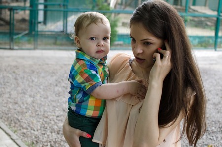 Young mother is walking with her small child in the parkの写真素材
