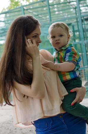Young mother is walking with her small child in the park