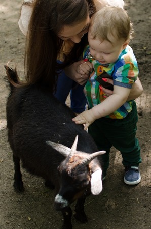 Young mother is walking with her small child in the parkの写真素材