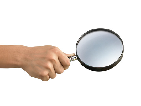 Hand holding a magnifying glass isolated on a white backgroundの写真素材