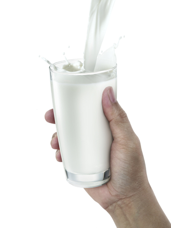 hand with glass of milk on a white backgroundの写真素材