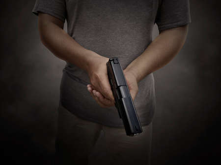 A man holding a gun in hand, the ship ready to shoot the man pointed a gun at us. A man holding a gun was robbedの写真素材