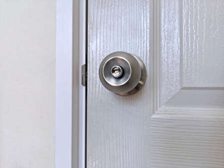 Aluminum door knob on the white door