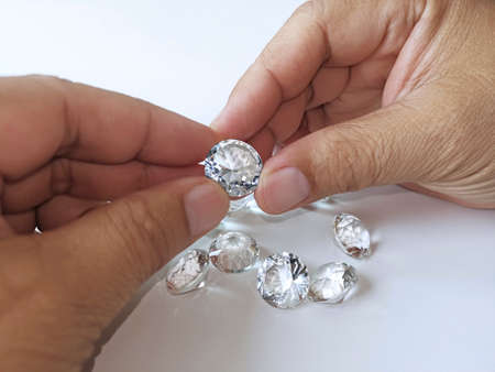 Close-up of the hand of jeweller gemologist with round cut diamondsの写真素材