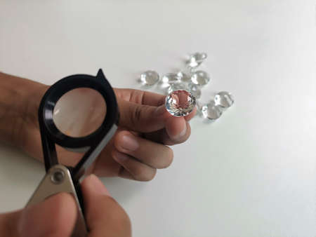 Gem stones. Jeweller checking polished diamond. Carat size diamonds. Diamond trading and dealing. Loose diamond grading. Precious stonesの写真素材