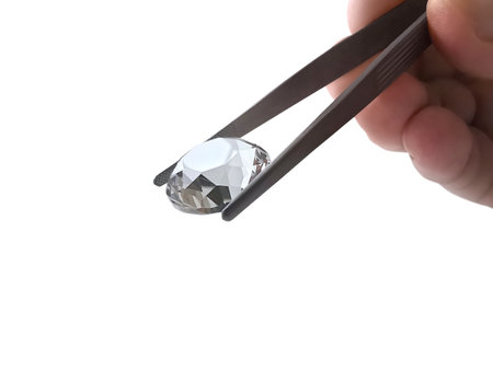 Diamond on square white background held in diamond tweezersの写真素材