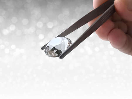 brilliant cut diamond held by tweezers on white shining bokeh background. concept for chossing best diamond gem designの写真素材