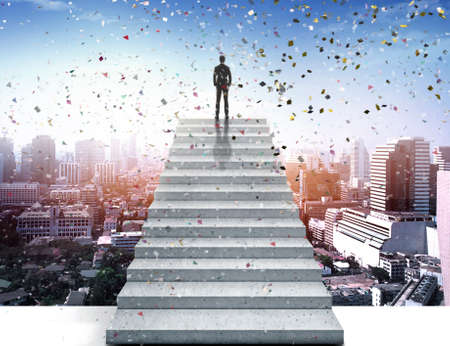 Vision concept. Successful businessman standing on staircase, on to celebrate and looking over cityの写真素材