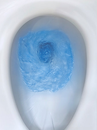 Top view of toilet bowl, blue detergent flushing in itの写真素材