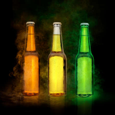 Beer bottle with water drops on the color smoke black backgroundの写真素材