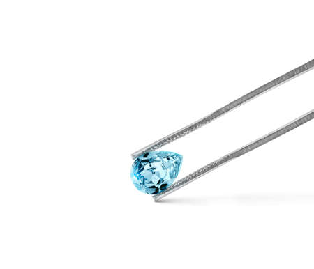 blue diamonds held in tweezers on a white backgroundの写真素材