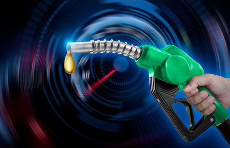 Holding a fuel injector against a speedometer on a blurred backgroundの写真素材