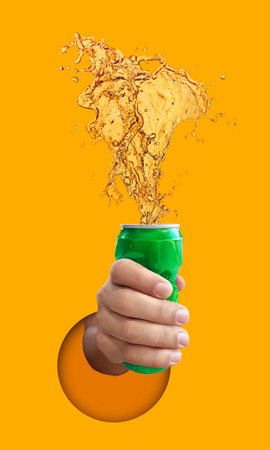 Man holding Cold beer splashing out of caned, on yellow backgroundの写真素材