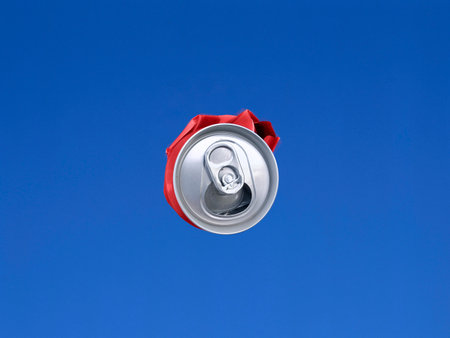 Compressed cans shot in the air with blue sky backgroundの写真素材