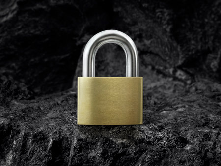 Metal padlock on black coal backgroundの写真素材
