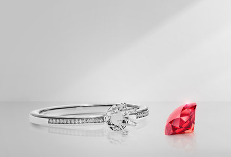 White gold or silver ring without gemstone and round red diamond with reflection on a backgroundの写真素材