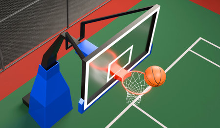 Orange basketball floating above the hoop net an outdoor basketball court at nightの写真素材