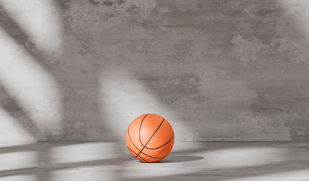 An orange basketball in a cement walled room and soft shadows from the windowの写真素材
