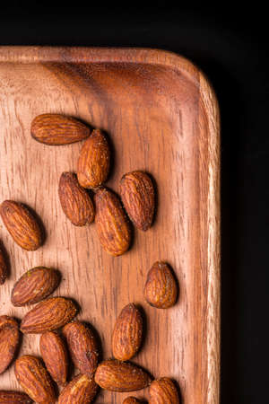 Toasted almonds  in a wood sish over a black board.の写真素材