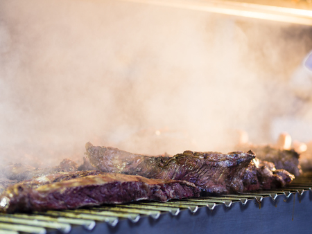 Grilling red meat and sausages at sunset outdoors gathering with friends and family,の写真素材