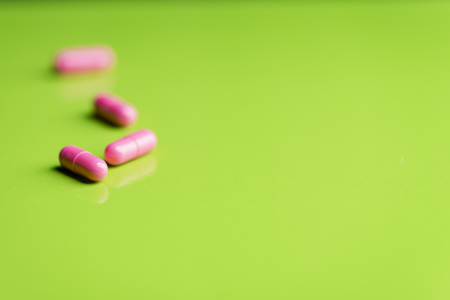 pink pills and medicine over a green table and backrgoundの写真素材