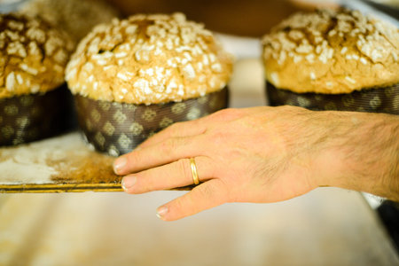 pastry chef in professional kitchen preparing and baking milanese panettone in christmas time....